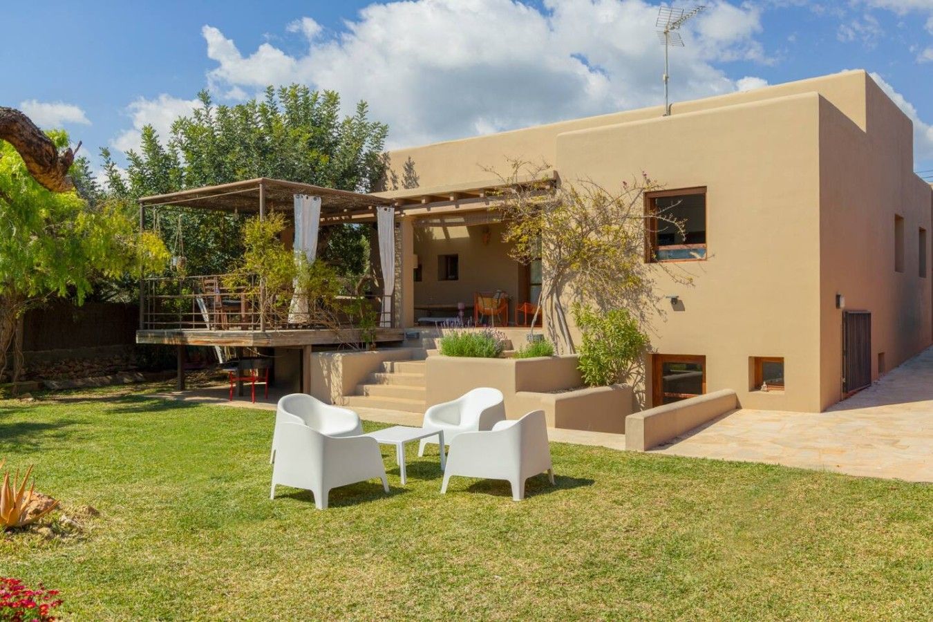 Une maison moderne à deux étages dotée d’un patio, d’un espace salon extérieur et d’une zone couverte.