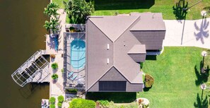A residential property with a swimming pool, a covered patio, and a dock extending into a body of water. - Villa Glasswater - Lake View, Kajaks & Dock (Cape Coral)