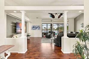A spacious lobby with a wooden floor, a seating area with leather sofas, a television, and artwork on the walls. - Villa Glasswater - Lake View, Kajaks & Dock (Cape Coral)