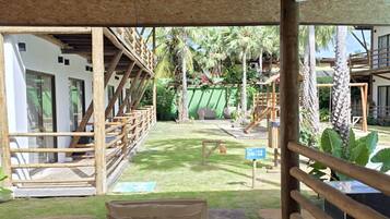 A covered outdoor seating area with a view of a pool and a wooden deck.