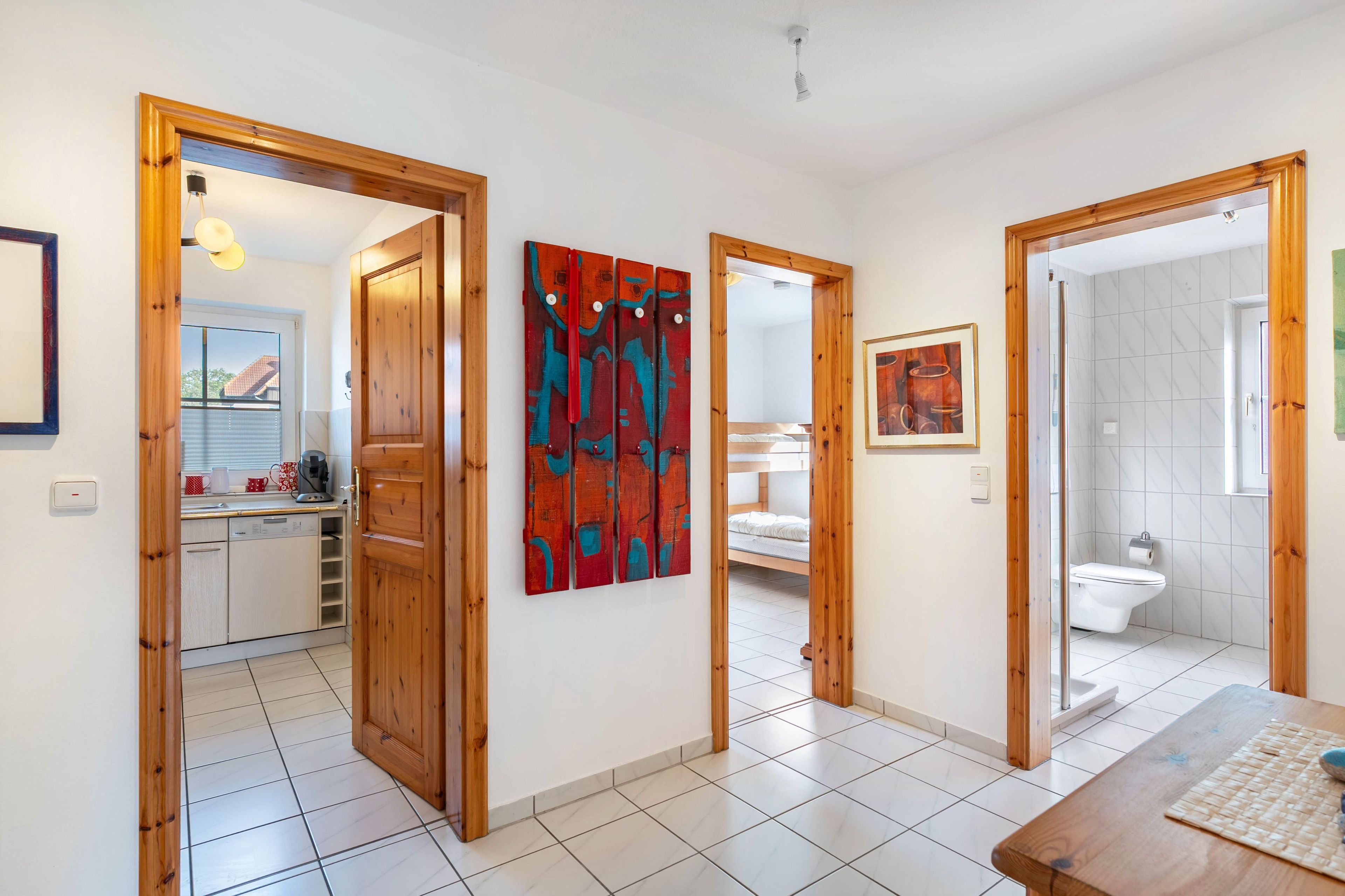 Een modern interieur met houten deuren, een keukenhoek, een badkamer en een eethoek.