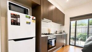 A modern kitchen with a refrigerator, stove, oven, and dishwasher. - The Glenroy Getaway – 2BR Parking & Wi-Fi (Glenroy)