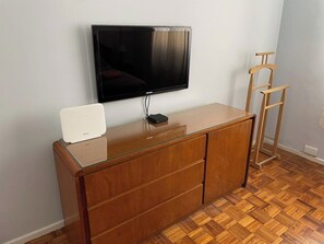 A room with a wooden cabinet, a flat-screen TV mounted on the wall, and a wooden ladder. - Los Arcos Palermo Palace (Buenos Aires)