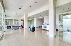 A spacious lobby with a reception desk, seating area, and large windows. - Starla Room Enviro Cikarang by BukaKamar (Cikarang/Bekasi)