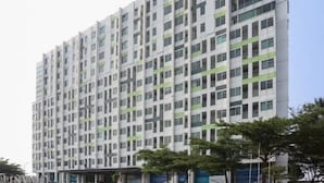 A multi-story building with a uniform facade, featuring a series of windows and balconies. - Starla Room Enviro Cikarang by BukaKamar (Cikarang/Bekasi)