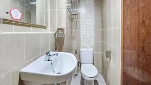 A bathroom with a white sink, toilet, and a shower area. - Starla Room Enviro Cikarang by BukaKamar (Cikarang/Bekasi)