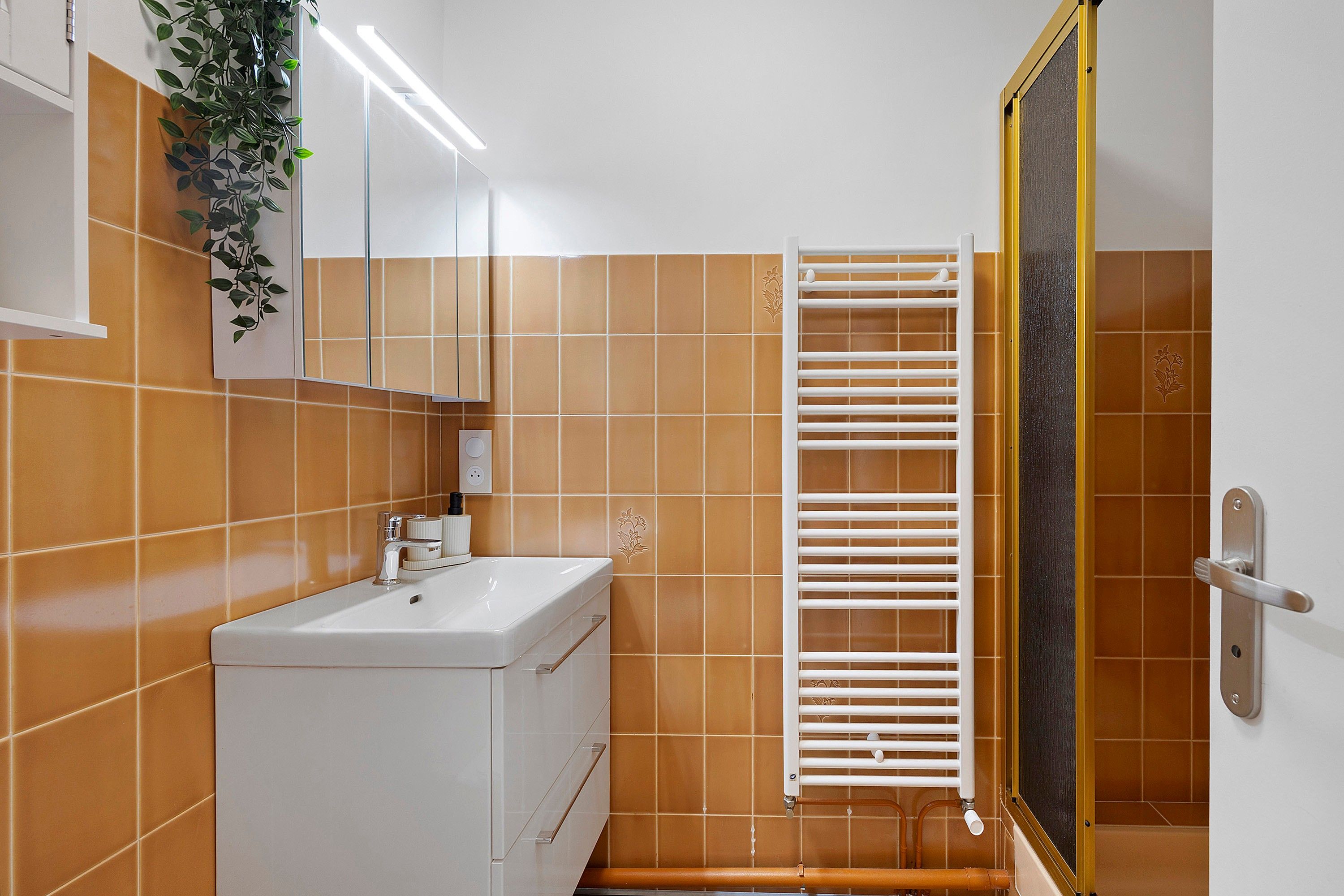 A bathroom with a white sink, a mirror, and a towel rack.