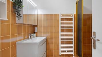 A bathroom with a white sink, a mirror, and a towel rack.