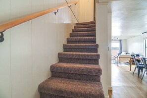 Un escalier dont les marches sont recouvertes de moquette, menant à un palier.
