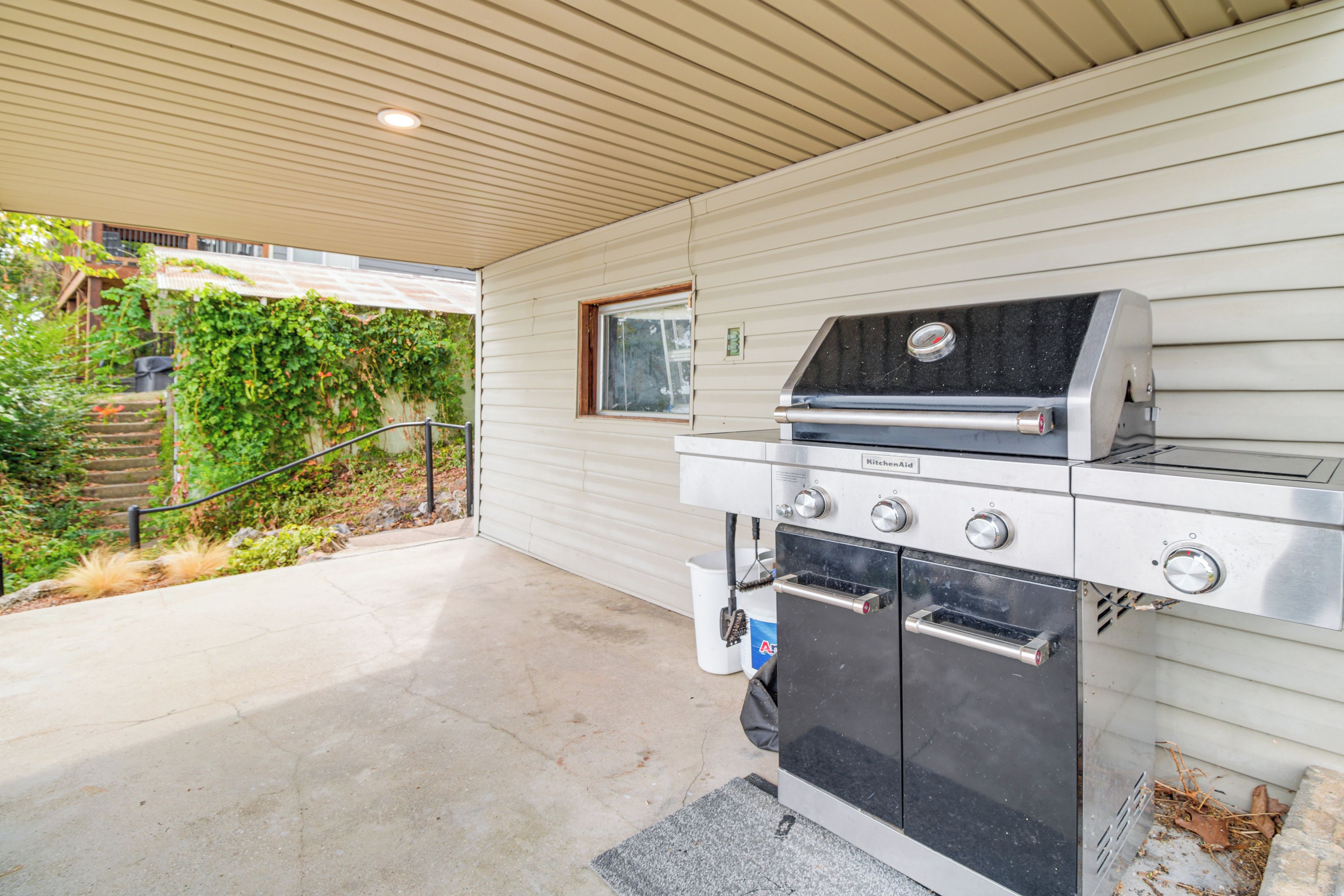 Cucina esterna con barbecue, forno e finestra.