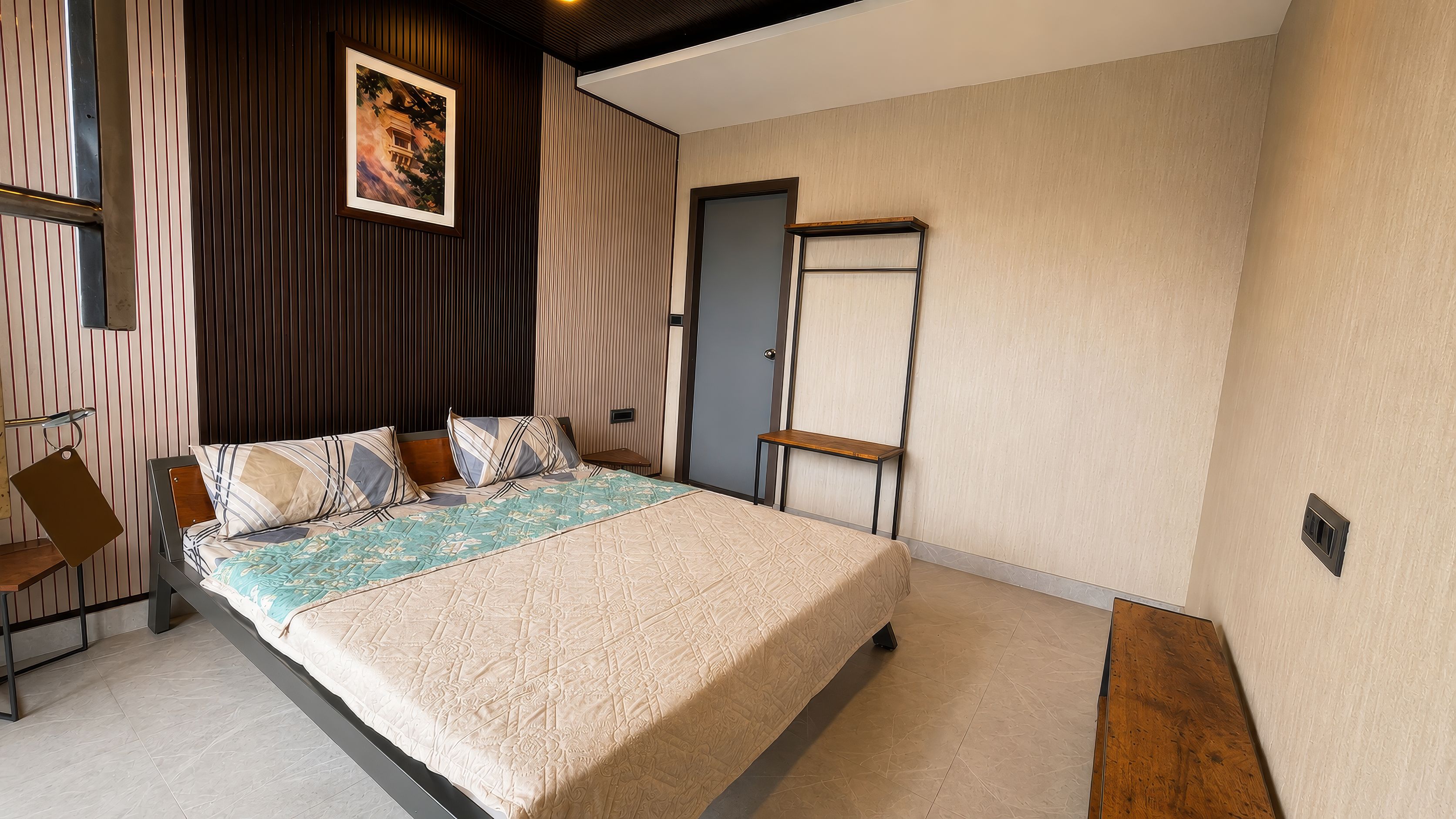 Un dormitorio con cama, mesitas de noche, armario y puerta.