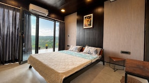 Un dormitorio con una cama grande, vistas al exterior y techo de madera.