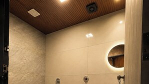 Un baño moderno con un lavamanos integrado, ducha y tocador con espejo.