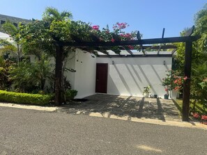A building with a white exterior, a dark door, and a covered entrance area. - Sosua Ocean Village - Las Palmas Villa #4 (Sosúa)