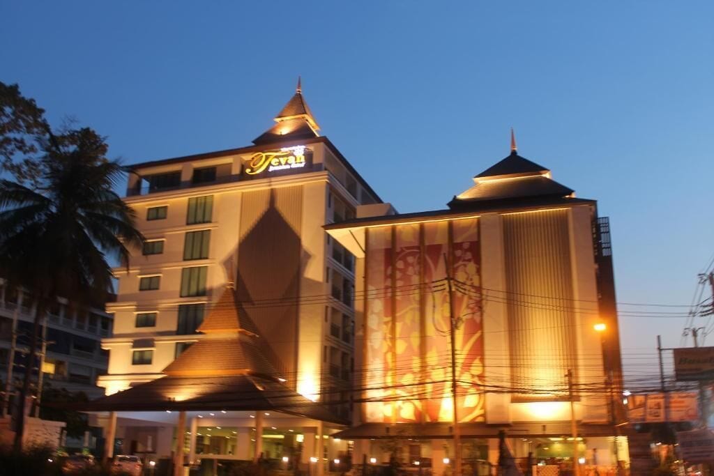 Un hotel con un cartel llamativo, varios pisos y una fachada iluminada.