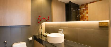 A modern bathroom with a toilet, sink, and shower.