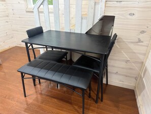 A wooden interior with a black metal table and bench. - Off the beaten path… (Algonquin Highlands)