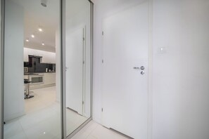 A modern kitchen with white cabinets, a black countertop, and a stainless steel oven. - Grzybowska City Center, Wola,Warsaw (Wola)