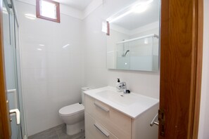 Ein Badezimmer mit Toilette, Waschbecken und Spiegel.