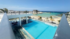 Una piscina con vista a la playa y al océano.