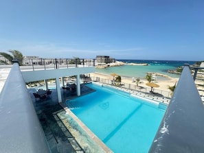 Ein Swimmingpool mit Blick auf Strand und Meer.