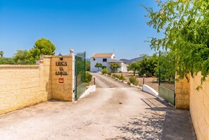 A gated entrance to a property named 'LINCA EL LAROL' with a clear path leading to a building with a tiled roof. - Cubo's Casa El Farol / Private pool / BBQ / Free Wi-Fi (Alhaurín el Grande)
