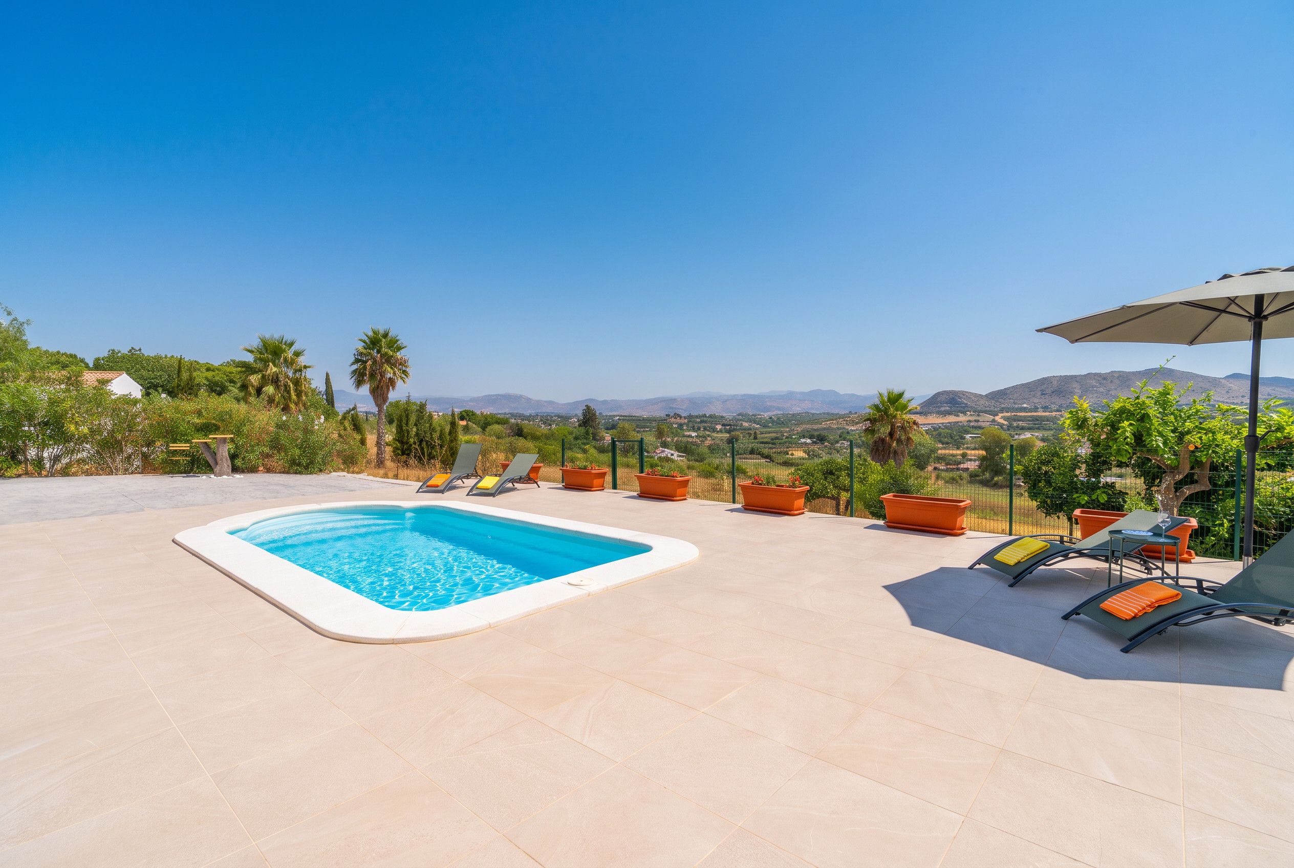 A swimming pool with lounge chairs and a view of the landscape.