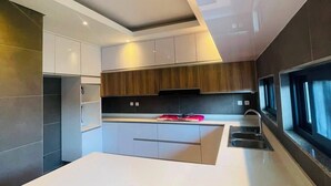 Una cocina moderna con una isla central, armarios empotrados y un amplio ventanal que proporciona luz natural.
