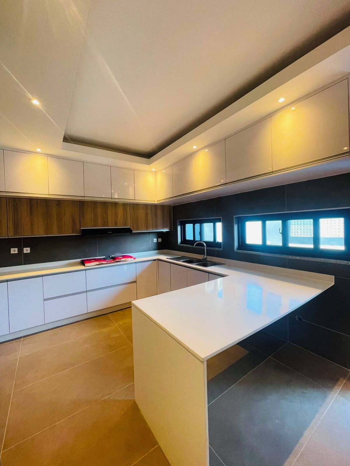 Uma cozinha moderna com ilha central, armários embutidos e janela que proporciona luz natural.