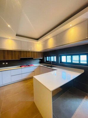 A modern kitchen with a central island, built-in cabinetry, and a window providing natural light.