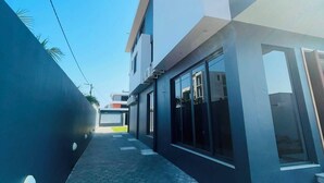 Un edificio moderno con un camino pavimentado y amplias ventanas.