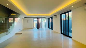 A spacious interior with a high ceiling, large windows, and a modern design.