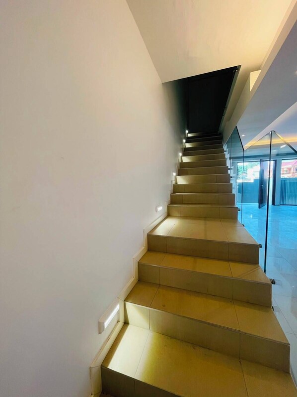 A modern staircase with glass railings leading to an upper level.