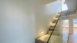 Una escalera moderna con barandillas de vidrio e iluminación integrada.