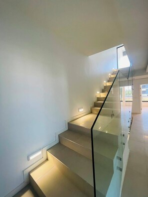 Eine moderne Treppe mit Glasgeländern und integrierter Beleuchtung.