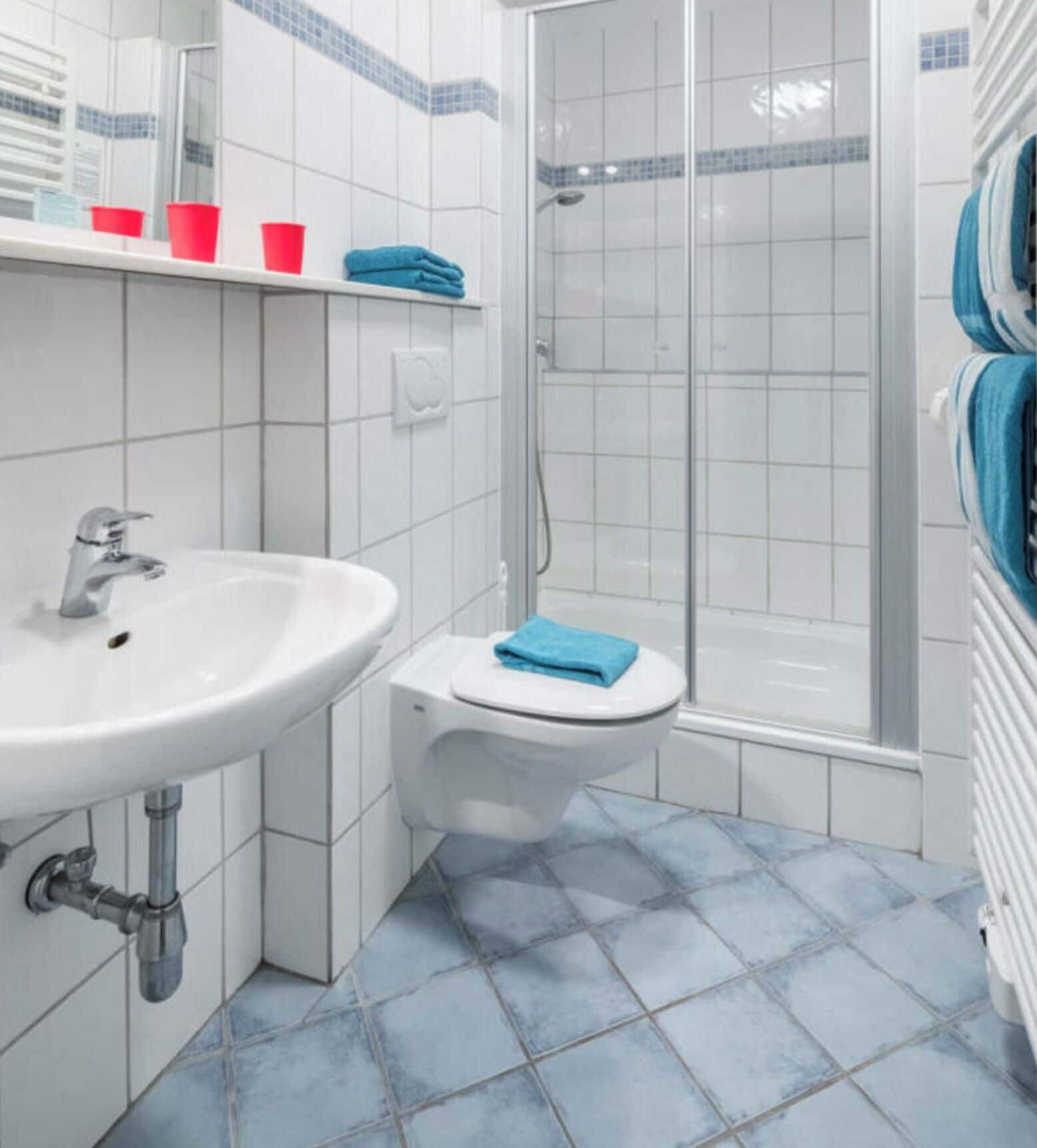Ein Badezimmer mit weißem Waschbecken, Toilette und Duschkabine.