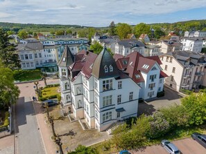 Un immeuble résidentiel à plusieurs étages, doté d’une tour centrale imposante et d’une façade symétrique.