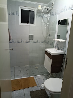 Un baño con ducha, inodoro y lavabo.