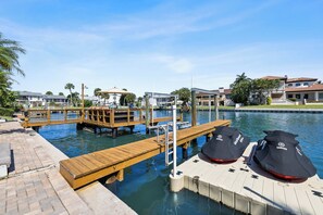 A marina with wooden docks, a swimming pool, and a Yamaha boat cover. - NEW! Luxury Waterfront Retreat, Private Pool, Dock & Sunrise Views 3Bed 3.5 Bath (St. Petersburg)