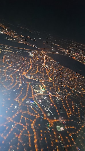 Ein Nachtbild der Stadt aus der Vogelperspektive, aufgenommen mit beleuchteten Straßen und Gebäuden.
