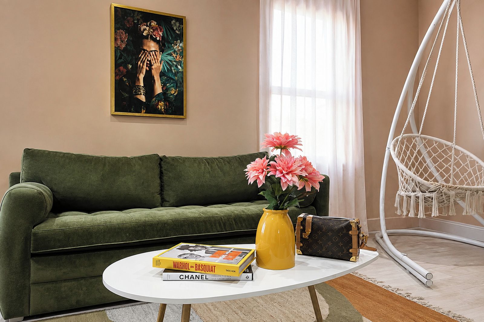 Ein grünes Sofa, ein weißer Couchtisch mit Büchern, eine gelbe Vase mit Blumen, eine Louis Vuitton Tasche und ein Hängekorbsessel.