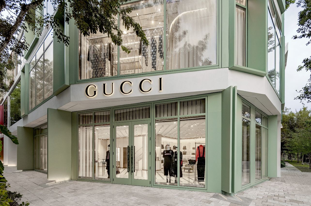 Ein GUCCI Geschäft mit einer modernen Fassade, großen Glasfenstern und dem deutlich sichtbaren Markennamen über dem Eingang.