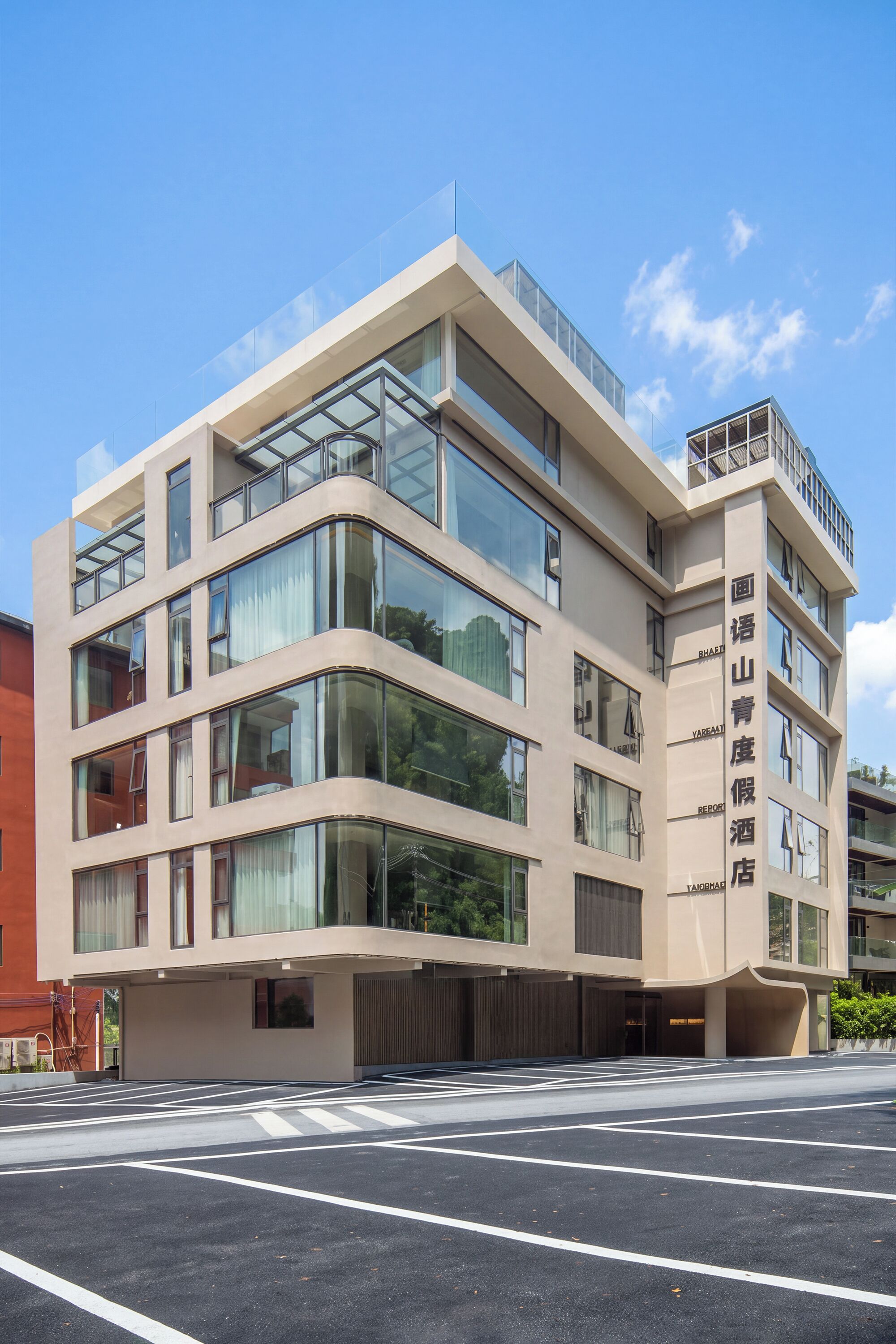 A multi-story hotel with a modern architectural design, featuring large windows and a flat roof.