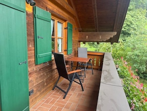 Eine Holzhütte mit Balkon, Tisch und Stühlen.