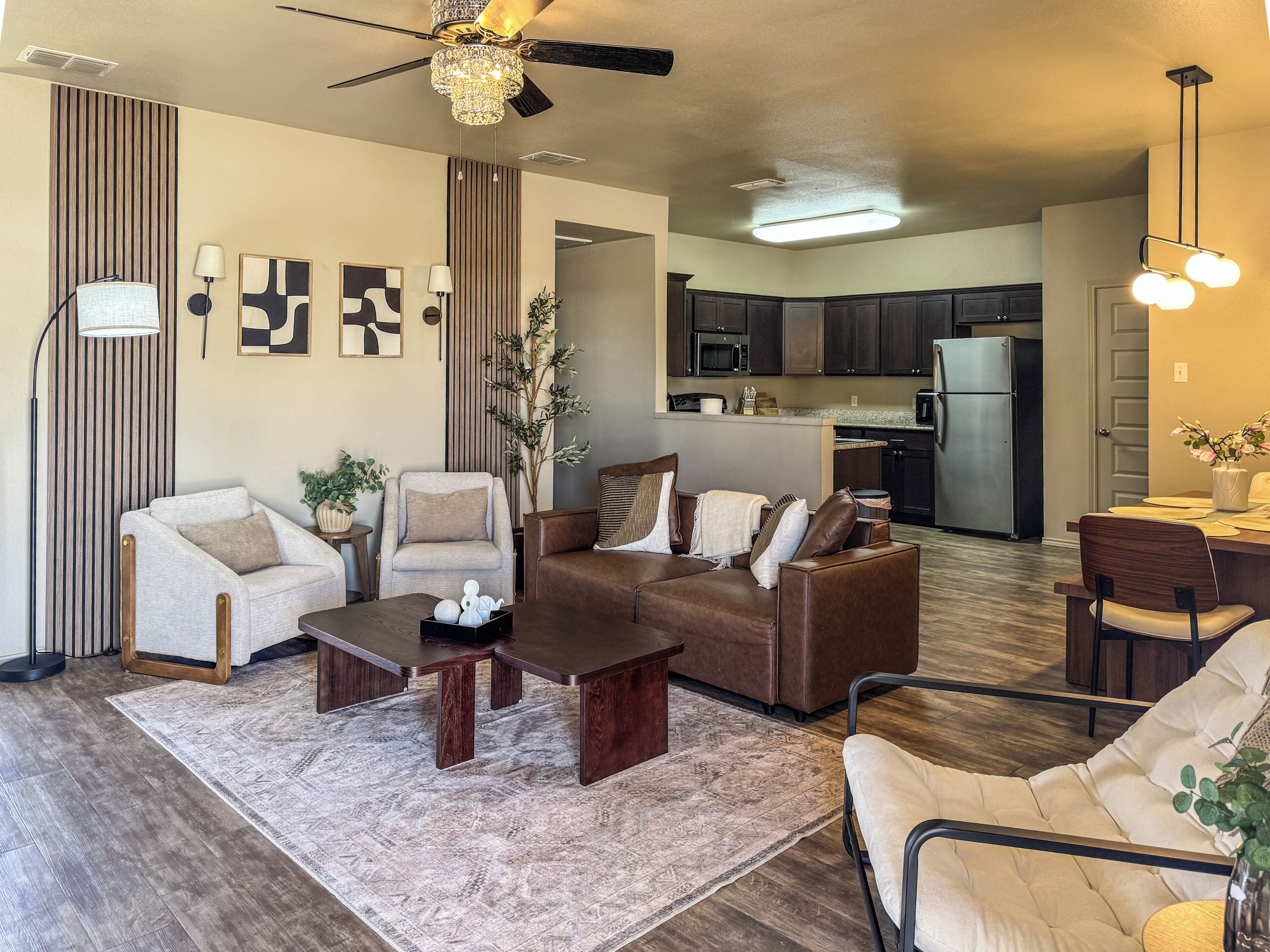 A modern living room with a sofa set, coffee table, and a dining area with chairs and a table.