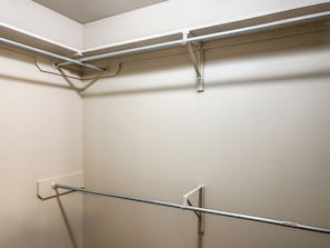 Un rincón de una habitación con una barra de metal y una pared blanca.