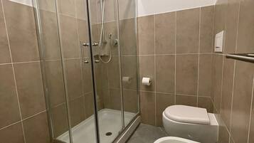 Ein Badezimmer mit Duschkabine, Toilette und Bidet.