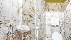 Um banheiro com paredes em estilo marmorizado, pia branca e vaso sanitário.