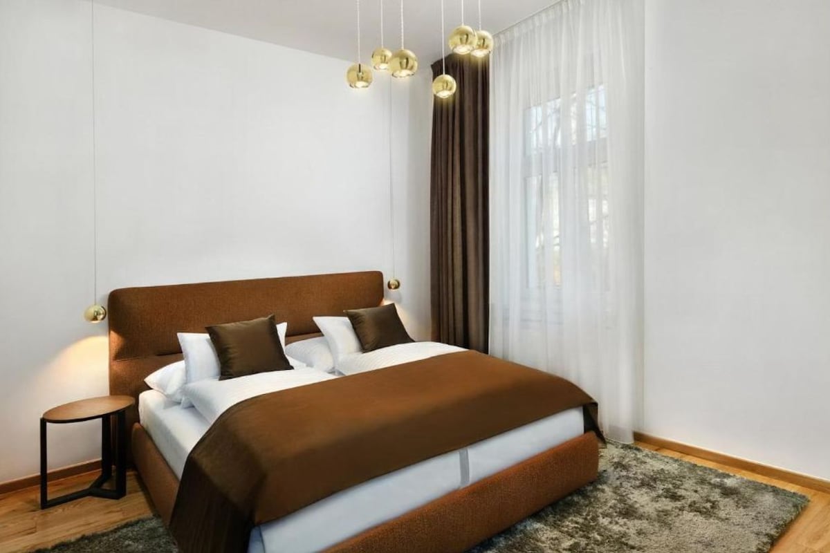 Ein modernes Schlafzimmer mit einem großen Bett, einem Nachttisch und einer Pendelleuchte.