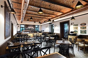 A restaurant with a brick ceiling, multiple tables, and chairs. - Apartmány Kuszmannov bazár (Vysoké Tatry)